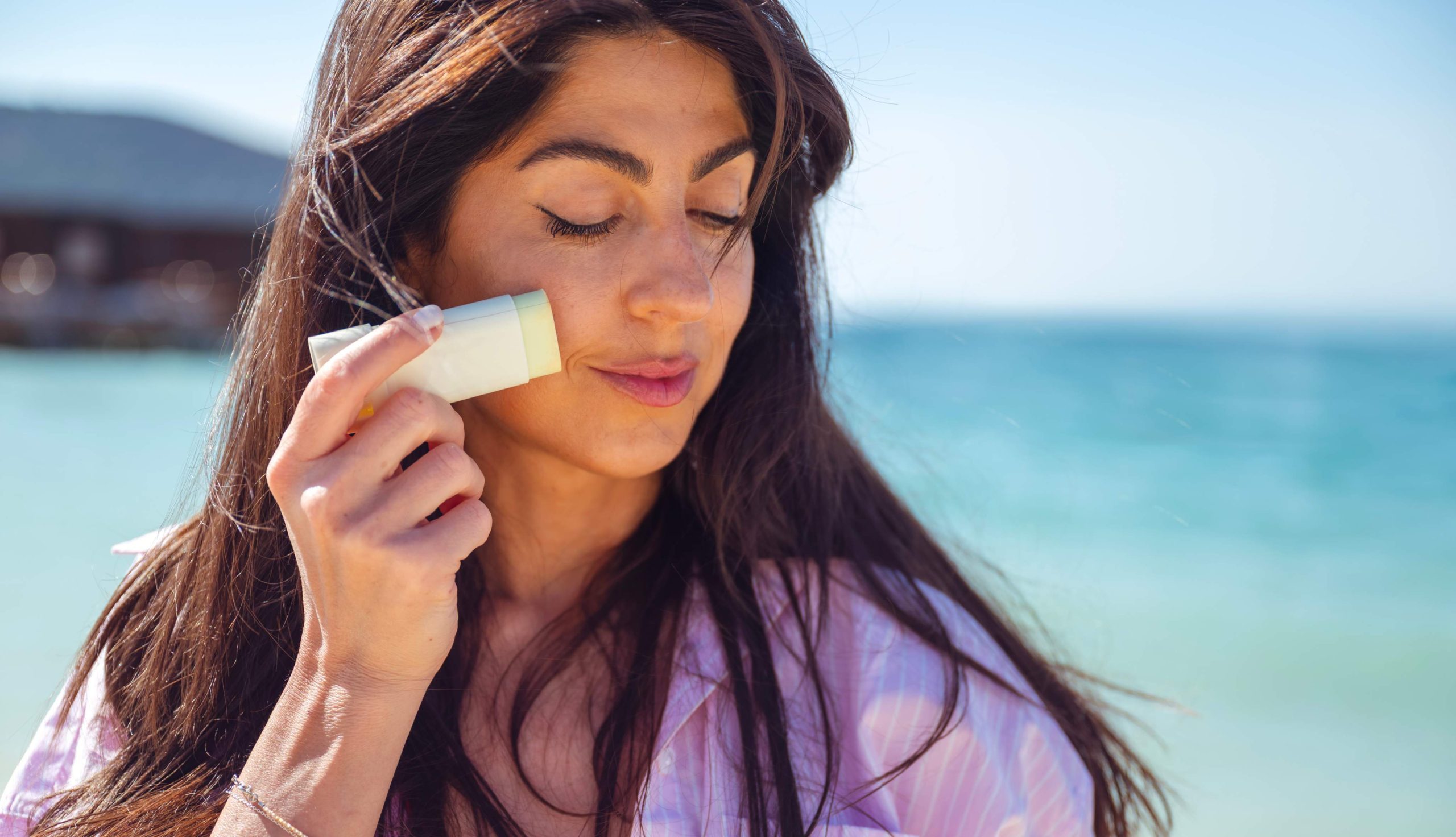 Woman applying a sun care product.