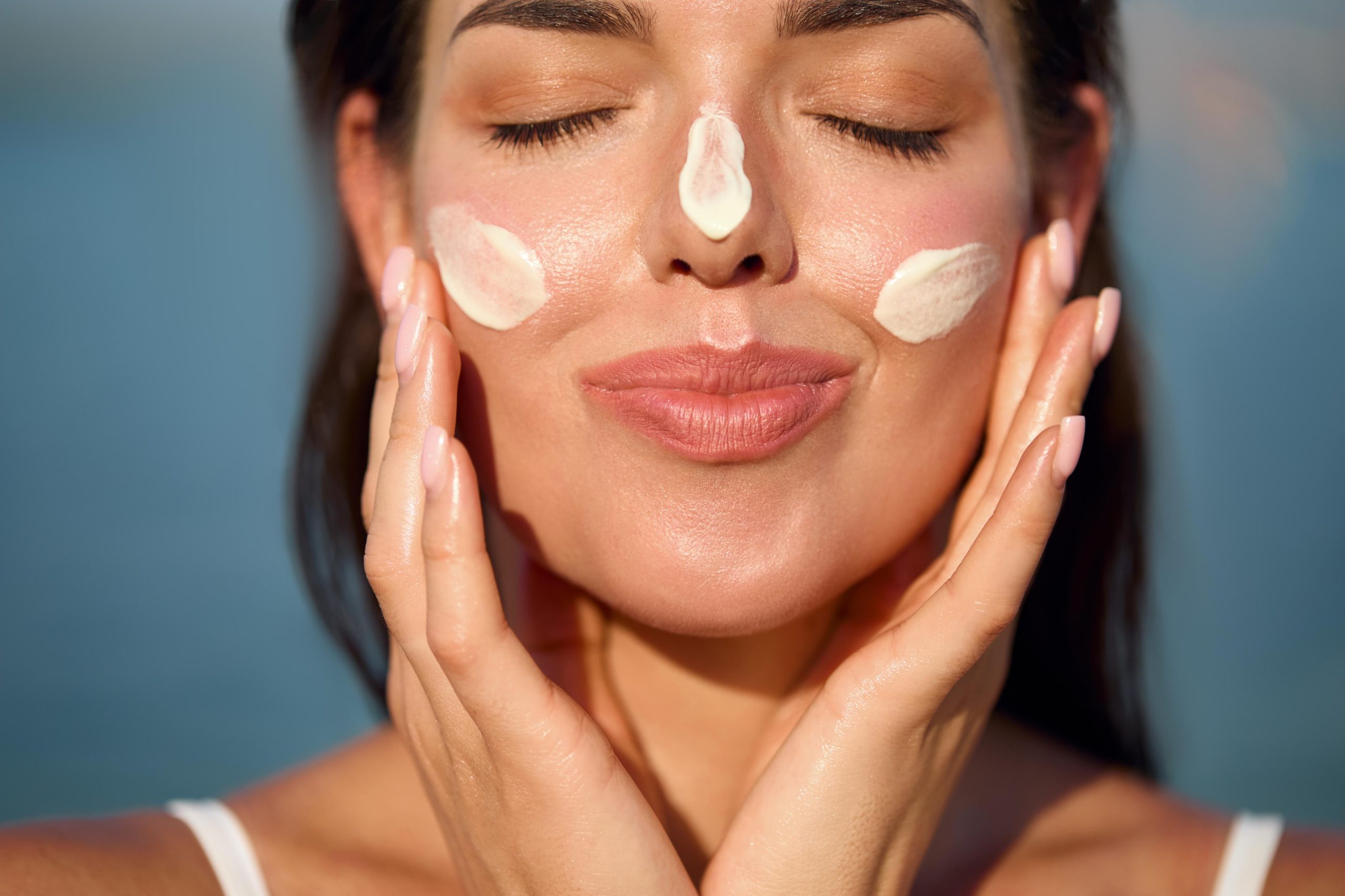 Woman applying suncare cream.