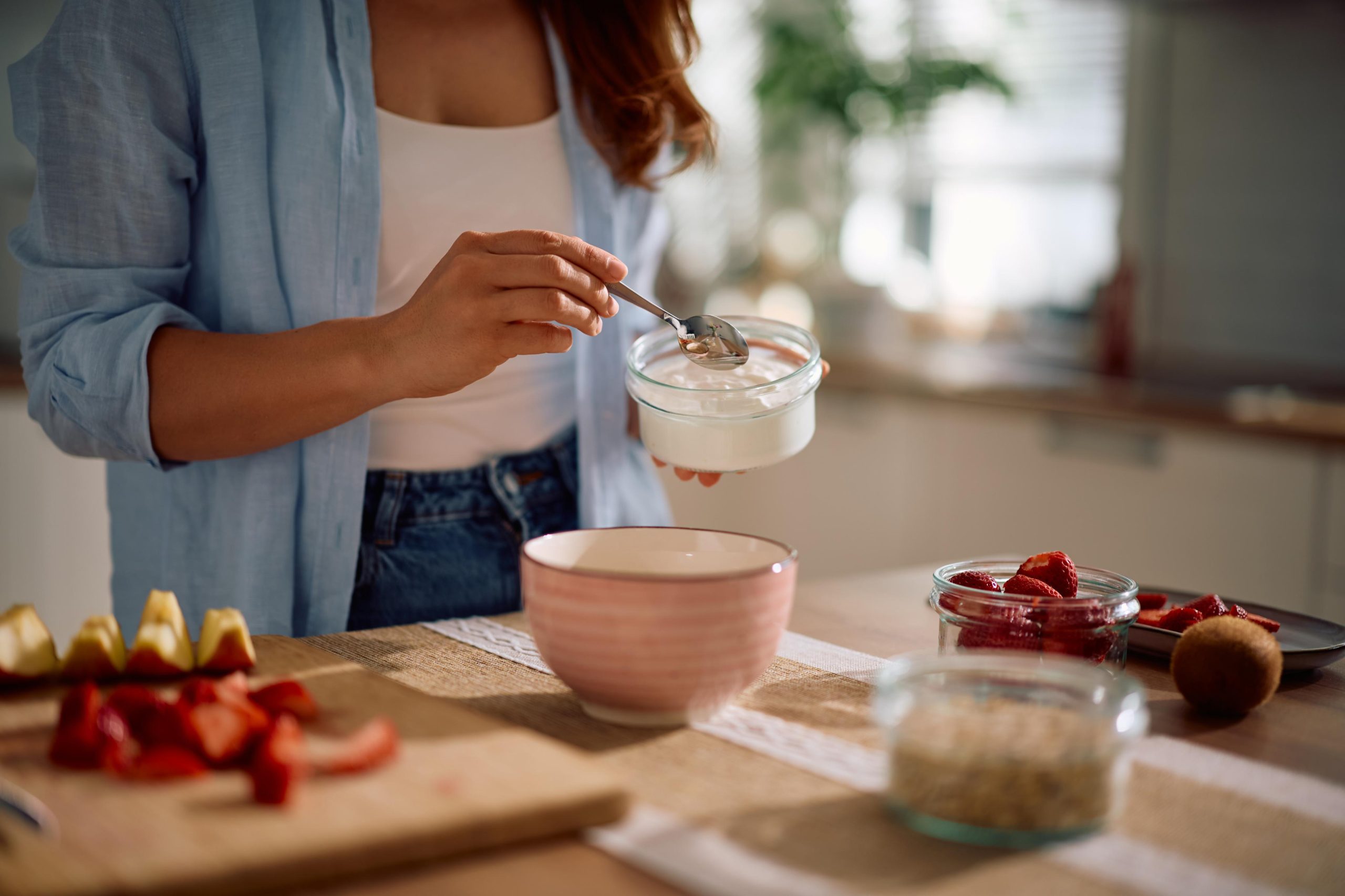 Woman preparing yogurt with alternative dairy product.