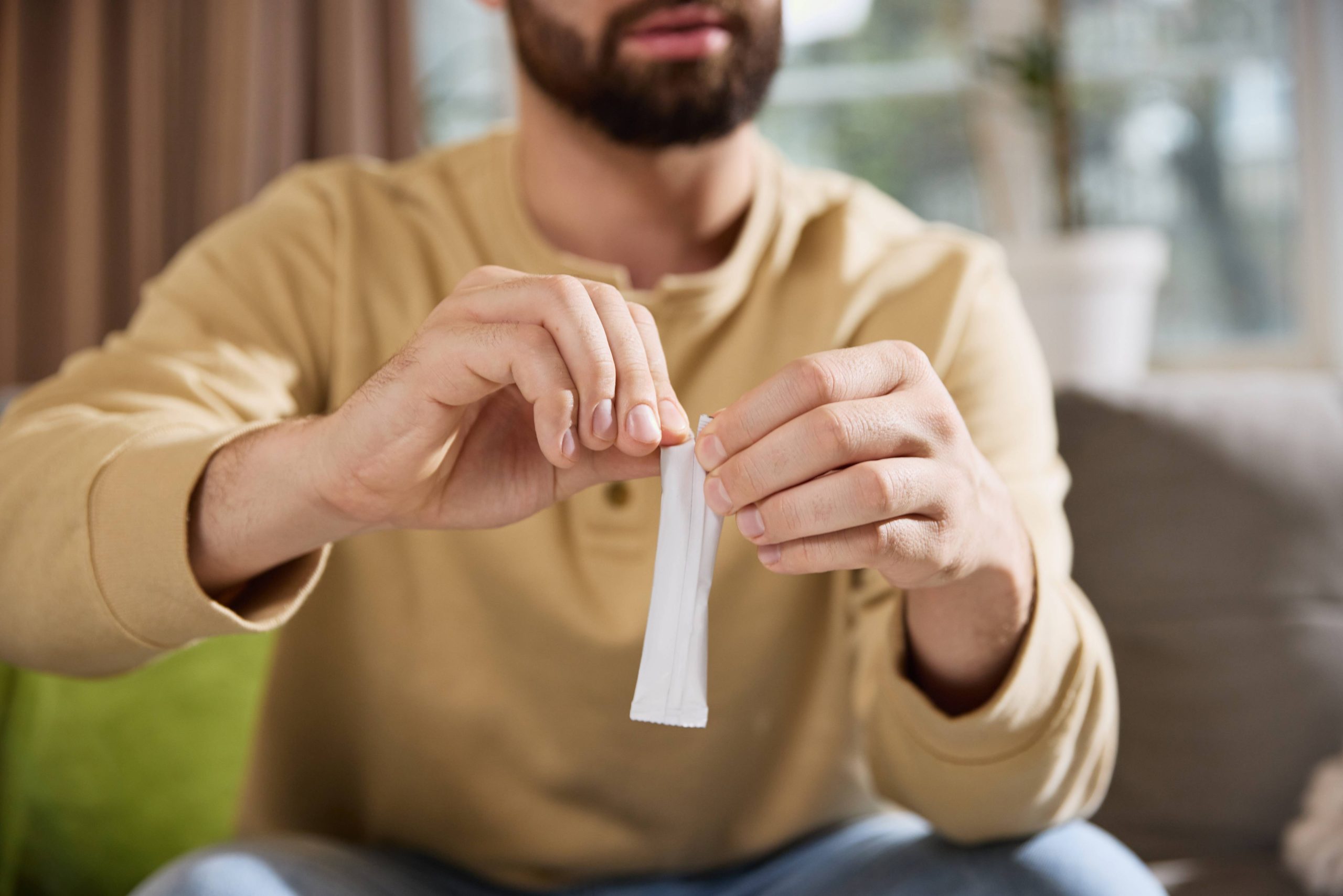 Man holding a sachet of orodispersible powder.