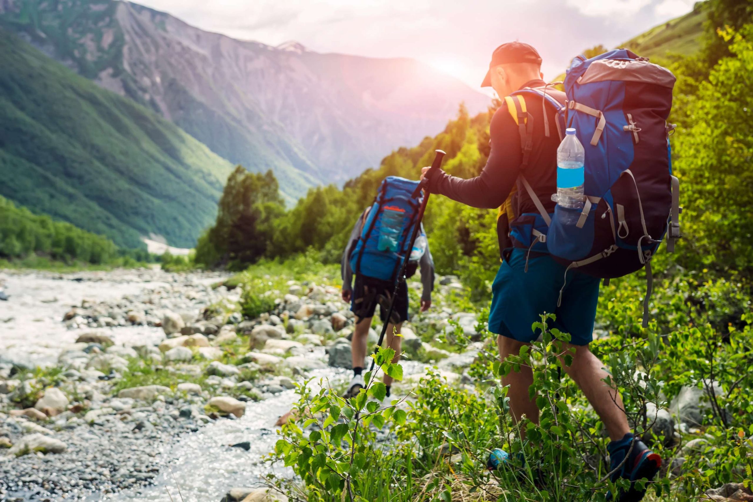 Tourists with hiking backpacks on beautiful mountain landscape background. Climbers hike to mounts. Group of hikers walking in mountains