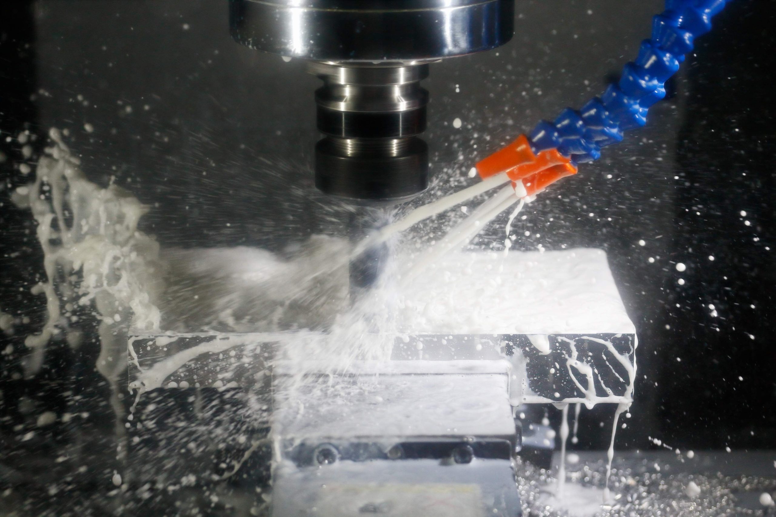 Milling process with coolant on a CNC machine. Milling process of aluminum using cutting fluid on a CNC milling machine. Selective focus.