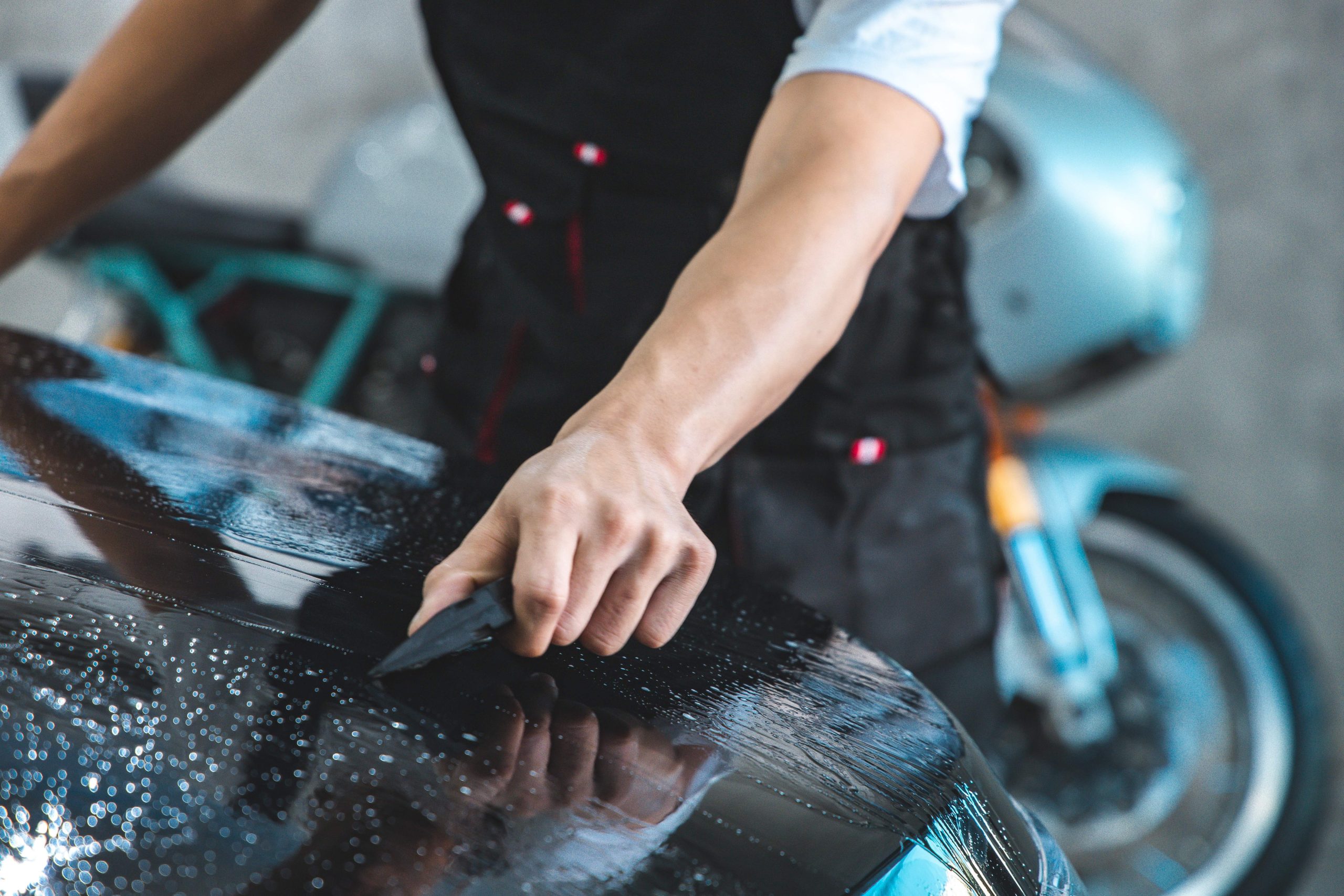 Paint protection film installation on door panel of luxury sports car. PPF is polyurethane film applied to car surface to protect the paint from rock chips & scratch..car coating detailing sticker .