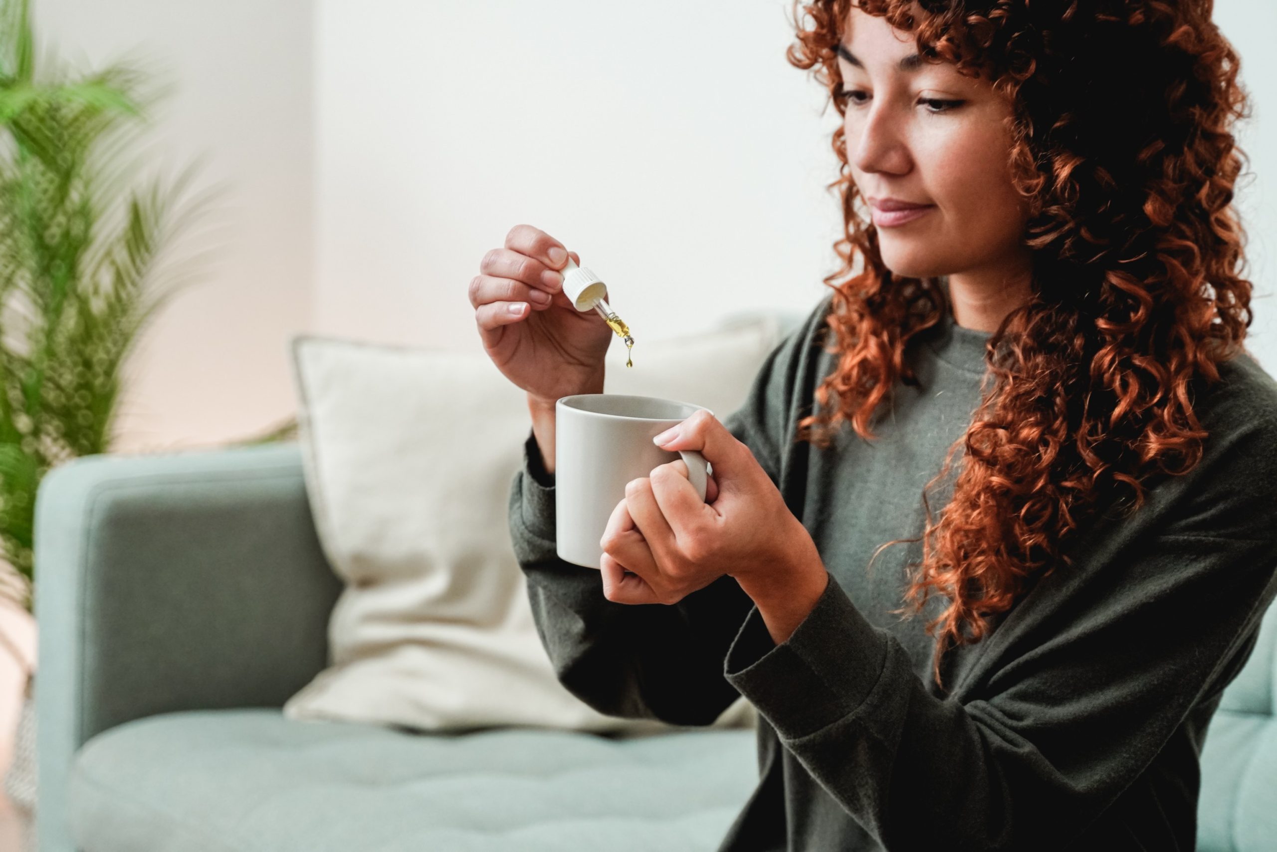 Woman holding a liquid pill.
