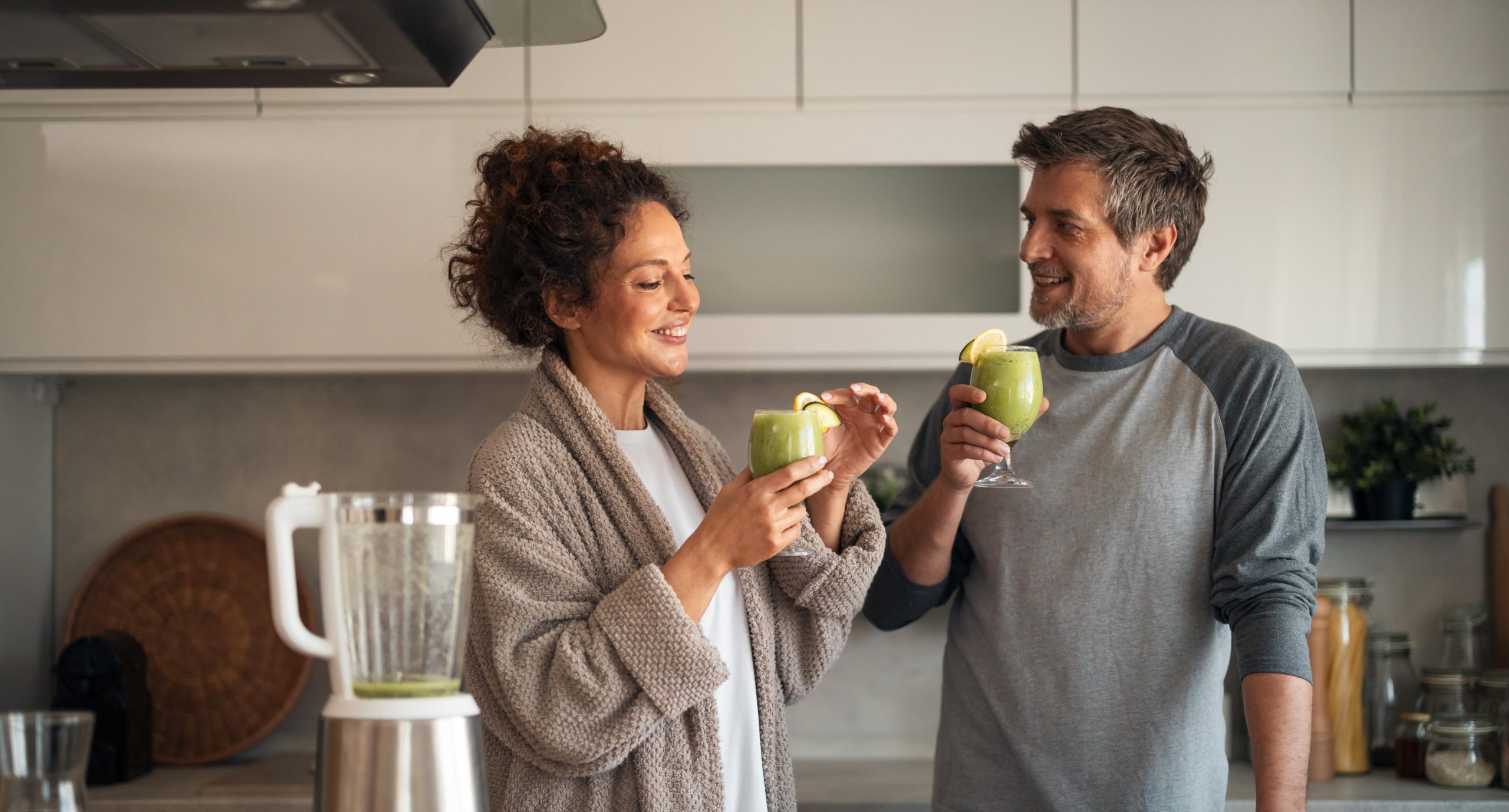 Couple preparing a smoothie together in a kitchen.